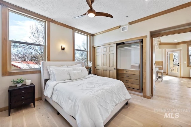 79 E Aikens Rd, Apt Eagle, ID 83616 - bedroom featuring ornamental molding, light wood finished floors, a textured ceiling, a closet, and ceiling fan