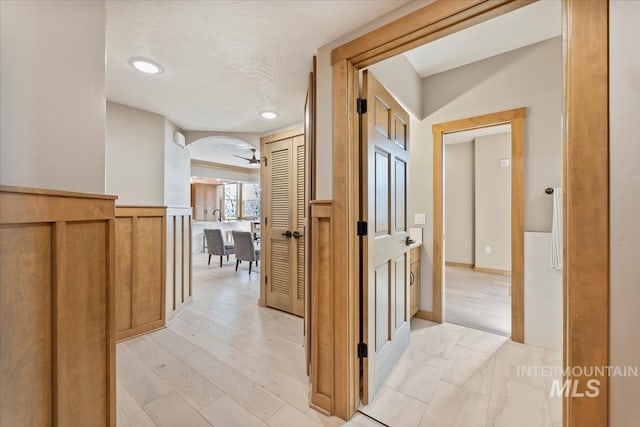 79 E Aikens Rd, Apt Eagle, ID 83616 - hall with wainscoting, arched walkways, recessed lighting, and light wood-type flooring