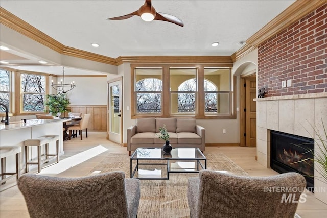 79 E Aikens Rd, Apt Eagle, ID 83616 - living area featuring ornamental molding, a ceiling fan, a wainscoted wall, a tile fireplace, and light wood-style floors
