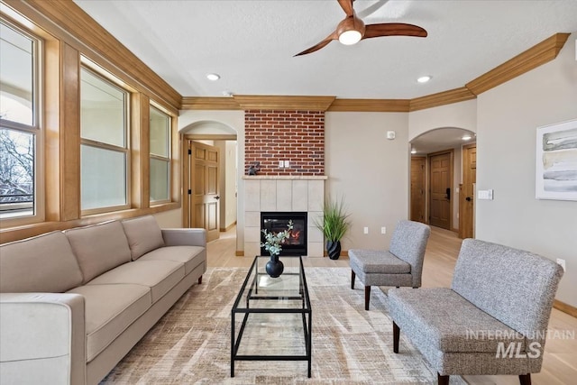 79 E Aikens Rd, Apt Eagle, ID 83616 - living area featuring arched walkways, a ceiling fan, ornamental molding, a tile fireplace, and recessed lighting