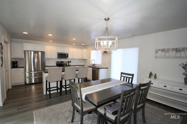 dining space with a chandelier, dark wood finished floors, and recessed lighting