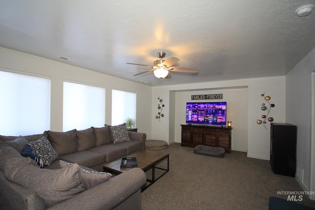 living room featuring carpet and a ceiling fan