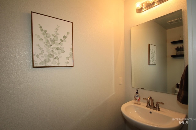 bathroom with visible vents and a sink