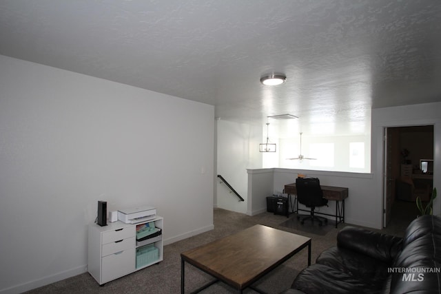 carpeted living area with a textured ceiling and baseboards