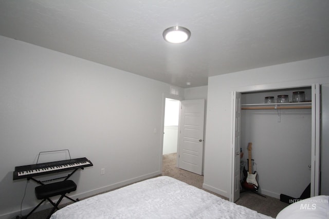 carpeted bedroom featuring a closet and baseboards