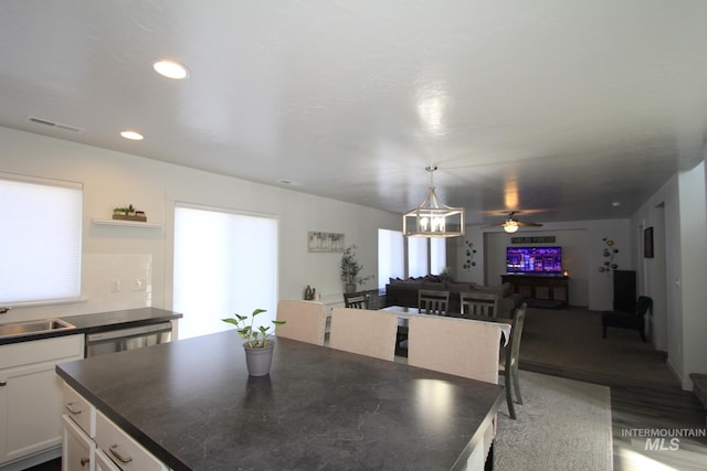 dining room with ceiling fan with notable chandelier, wood finished floors, and recessed lighting