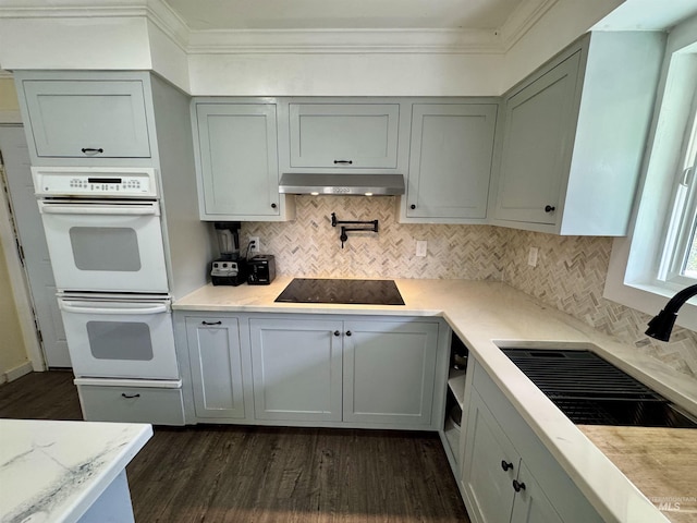 250 Hill Rd, Orofino, ID 83543 - kitchen featuring dark wood finished floors, black electric stovetop, under cabinet range hood, double oven, and ornamental molding