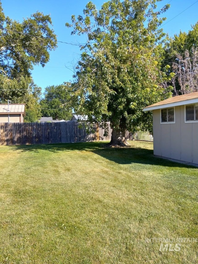 view of yard featuring an outbuilding and fence