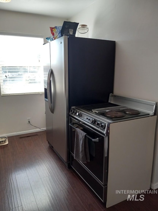 kitchen featuring baseboards, range with electric cooktop, and dark wood finished floors