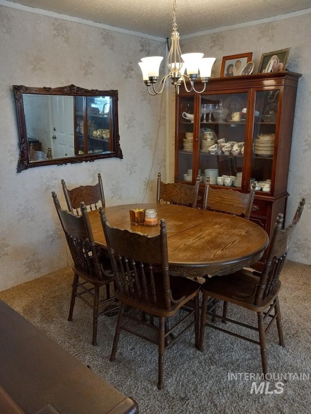 dining area featuring a notable chandelier, wallpapered walls, and crown molding