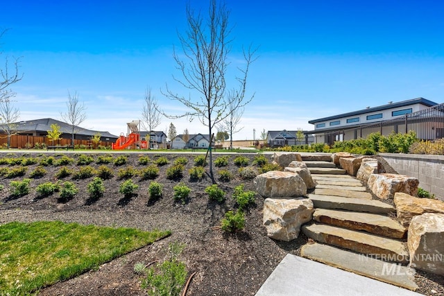 view of yard with fence, playground community, and a residential view