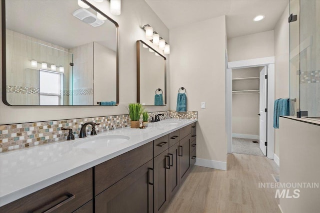 bathroom featuring decorative backsplash, vanity, hardwood / wood-style flooring, and walk in shower