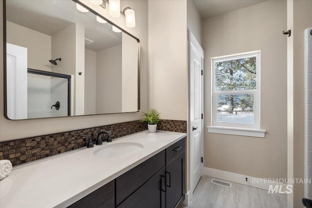 bathroom featuring vanity and a shower with door