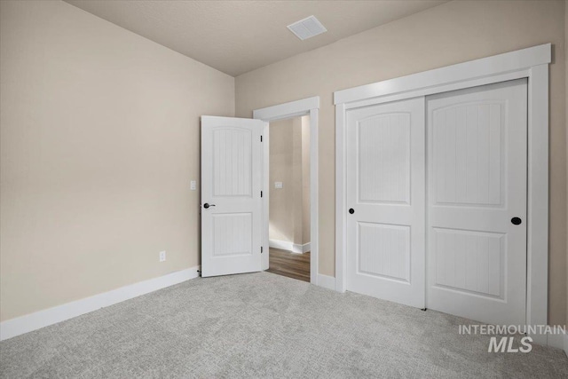 unfurnished bedroom featuring carpet flooring and a closet