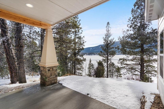 snow covered patio with a mountain view