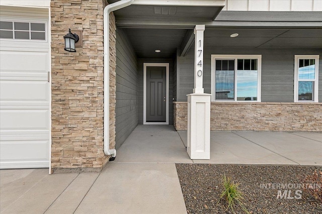 entrance to property with stone siding and an attached garage