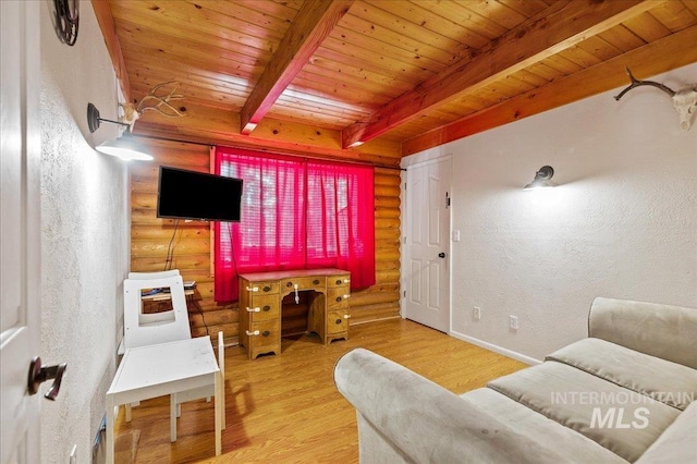 living area with a textured wall, wooden ceiling, wood finished floors, beamed ceiling, and rustic walls