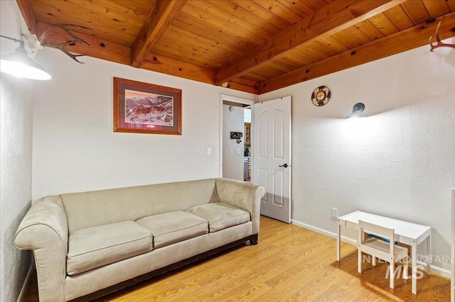 living room featuring light wood-style floors, wooden ceiling, beamed ceiling, and baseboards