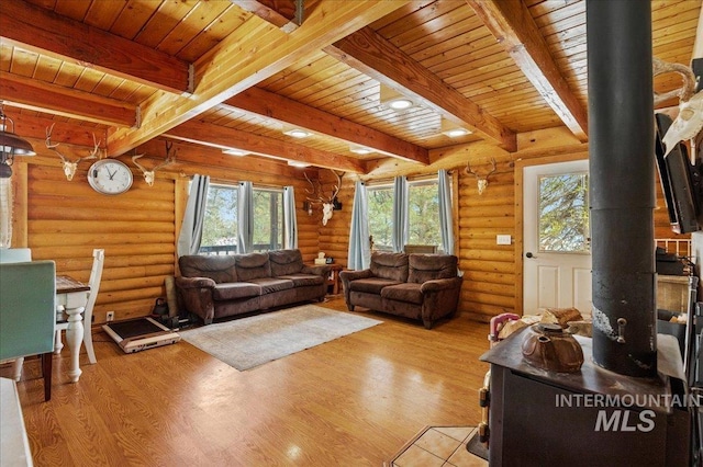 living area featuring a wood stove, light wood-type flooring, and wood ceiling