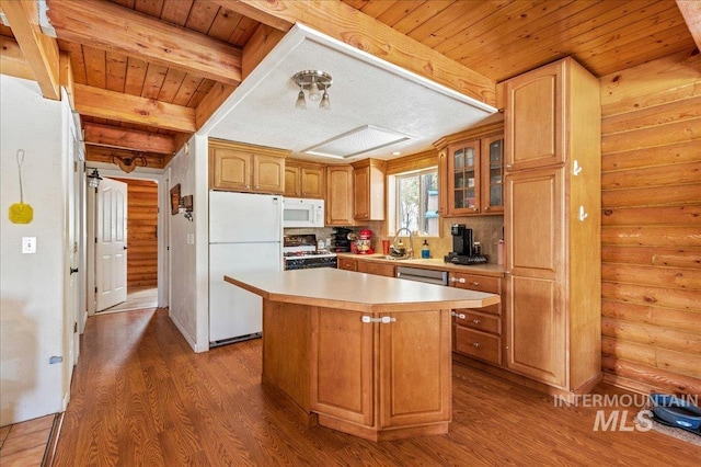 kitchen featuring a center island, light countertops, glass insert cabinets, a sink, and white appliances