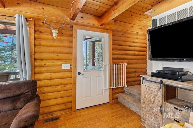 entrance foyer featuring rustic walls, visible vents, wooden ceiling, beamed ceiling, and light wood-style floors