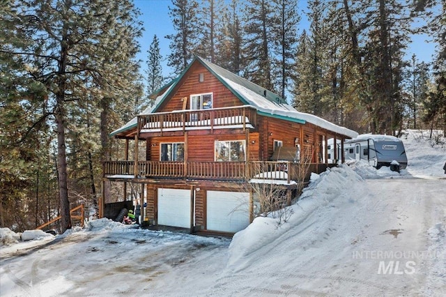 view of front of property featuring a garage, log veneer siding, and a porch