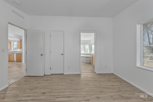 3911 Clark Blvd, Ontario, OR 97914 - unfurnished bedroom with multiple windows, light wood-style flooring, and connected bathroom
