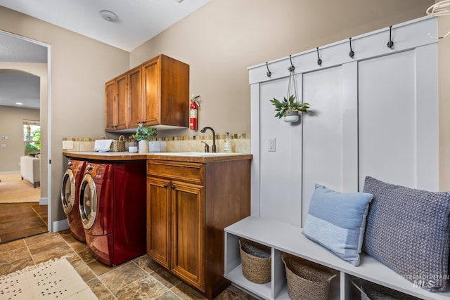 731 E Eaglewoods Ln, Eagle, ID 83616 - washroom featuring separate washer and dryer, arched walkways, cabinet space, and light stone finish floors