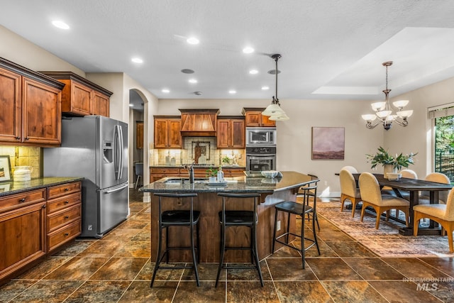 731 E Eaglewoods Ln, Eagle, ID 83616 - kitchen with stainless steel appliances, a chandelier, arched walkways, a breakfast bar, and recessed lighting
