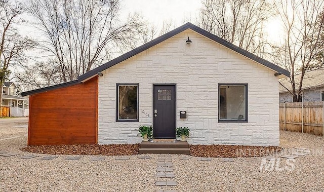 view of front of home with fence and stone siding