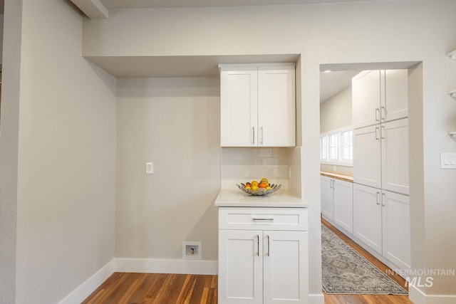 laundry room featuring cabinet space, dark wood-style floors, and baseboards