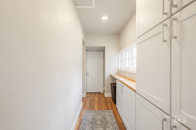 corridor with dark wood-style floors and baseboards