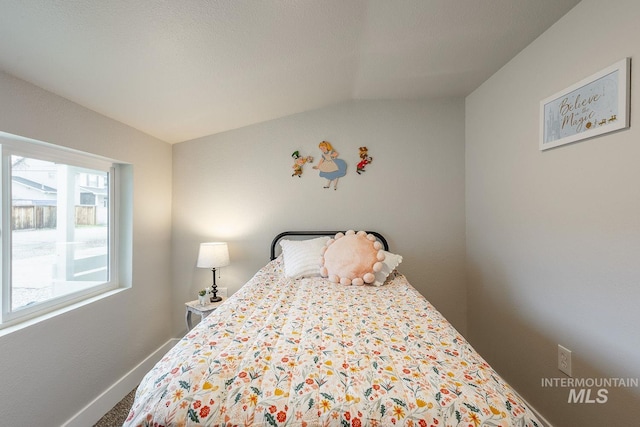 bedroom with vaulted ceiling and baseboards