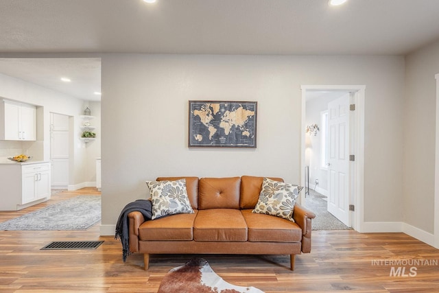 living area with recessed lighting, baseboards, visible vents, and light wood finished floors