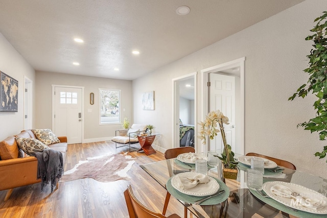 dining room featuring recessed lighting, light wood-style flooring, a textured ceiling, and baseboards