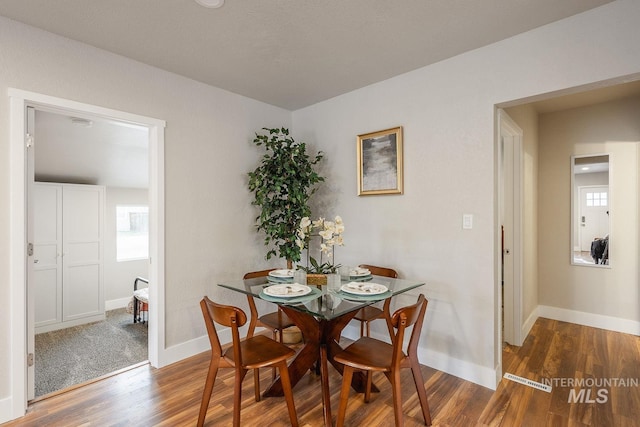 dining area with plenty of natural light, wood finished floors, and baseboards