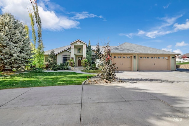 view of front of home with a front yard and a garage