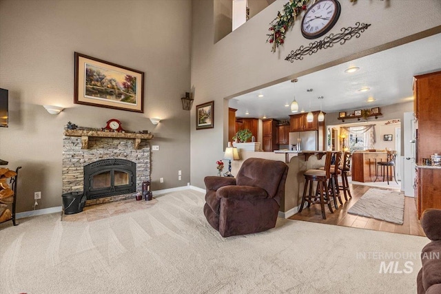 living room with light colored carpet, baseboards, and a fireplace