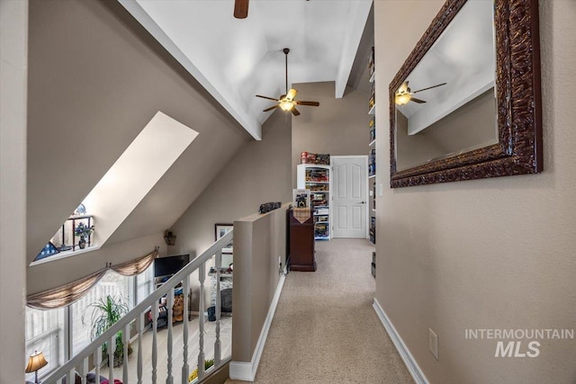 hall featuring baseboards, vaulted ceiling with beams, carpet, and an upstairs landing