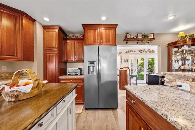 kitchen featuring recessed lighting, light wood-style flooring, a toaster, and stainless steel fridge with ice dispenser