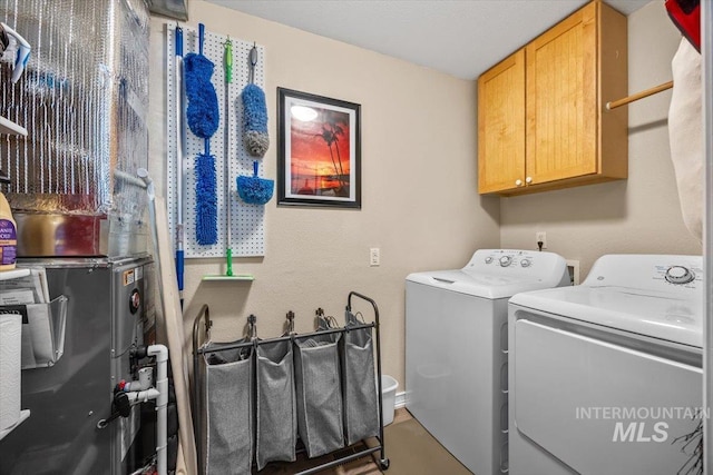 clothes washing area featuring cabinet space and washer and dryer