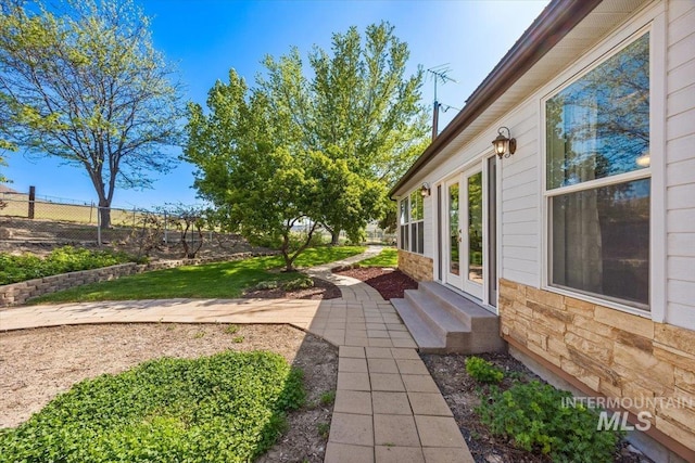 view of yard with fence and french doors