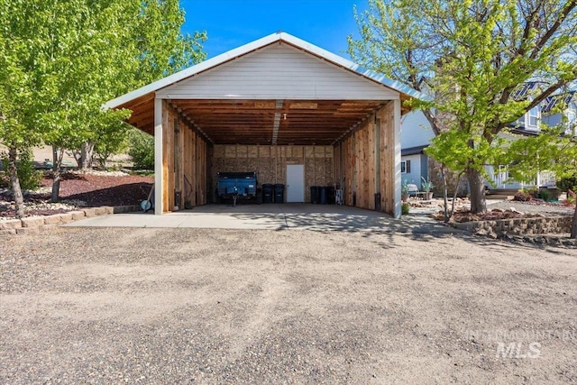 view of parking with a detached carport and driveway