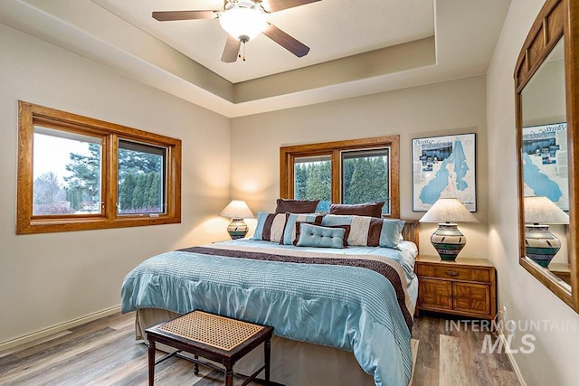 bedroom featuring wood finished floors, baseboards, and ceiling fan