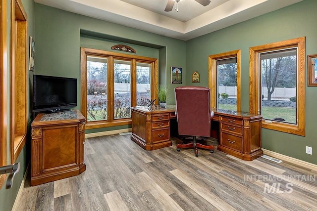 home office featuring wood finished floors, visible vents, and ceiling fan