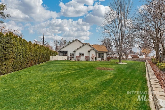 rear view of property featuring a lawn
