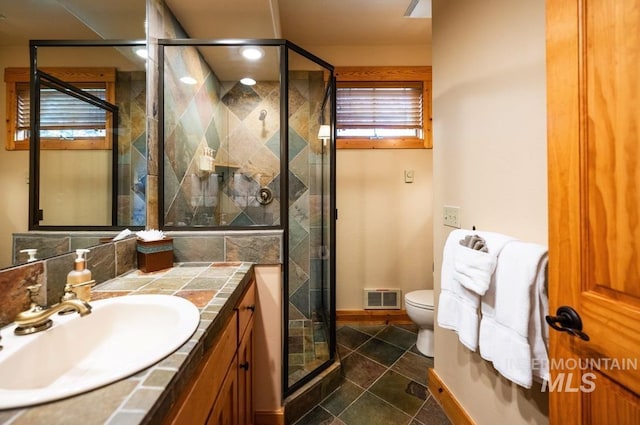 full bath with vanity, a shower stall, toilet, and visible vents