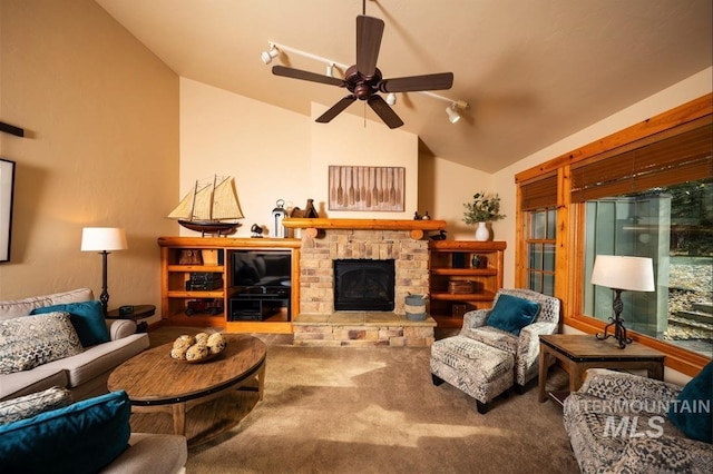 living room featuring carpet floors, ceiling fan, a fireplace with raised hearth, and lofted ceiling