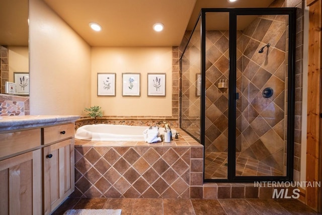 bathroom featuring recessed lighting, vanity, a garden tub, and a stall shower