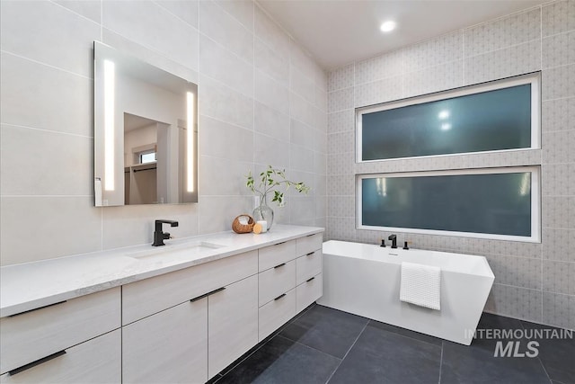 3359 E Warm Springs Ave, Boise, ID 83716 - bathroom featuring tile walls, a soaking tub, vanity, and tile patterned floors